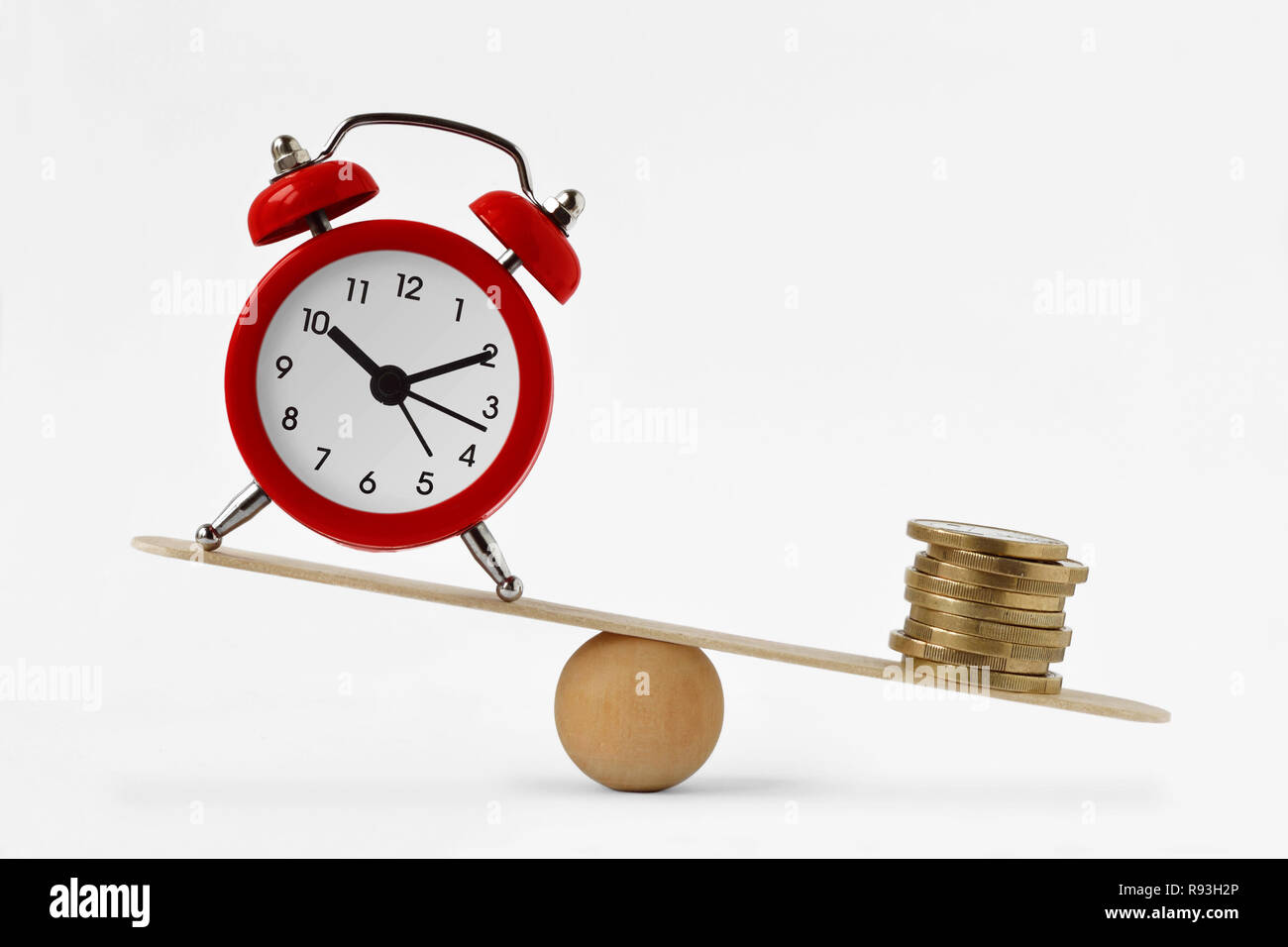 Uhr und Geld auf Skalen - Ungleichgewicht zwischen Zeit und Geld, Zeit und Geld Konzept Stockfoto