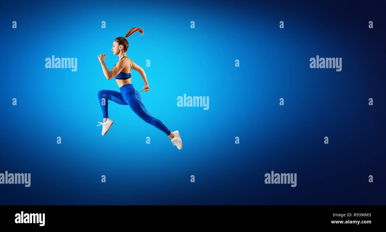 Junge Frau Läufer in blau Sportbekleidung Sprung in der Luft. Stockfoto