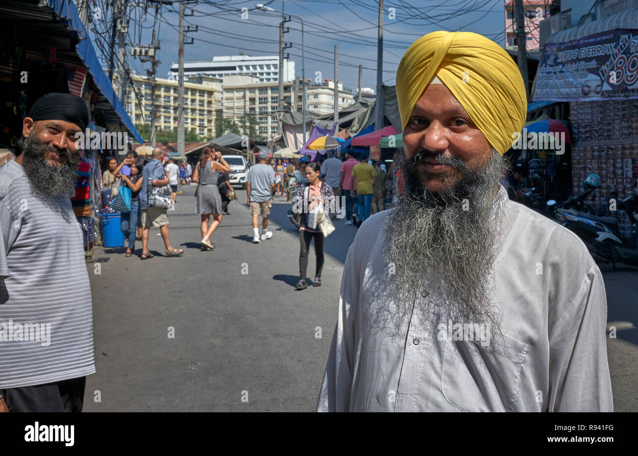 Indische Sikh Mann in traditionellen Kurta pajama Shirt und Turban headwear gegen seinen westlichen attired Gegenstück - moderne versus traditionelle Stockfoto