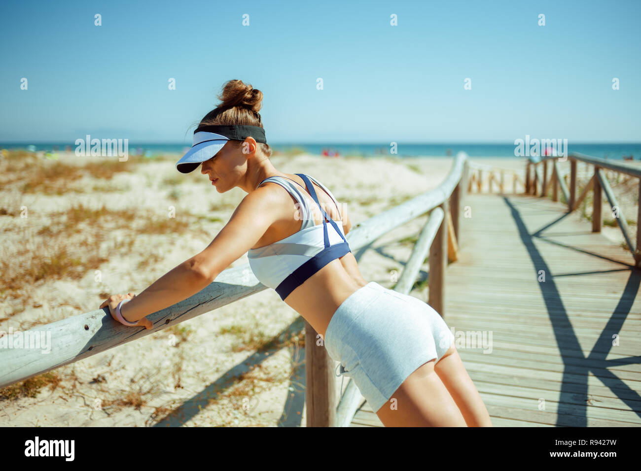 Sportlich aktive Frau in Fitness Kleidung auf dem Ozean Küste tun pushups. kurze Bursts von hoher Intensität Übungen perfekten Körper zu erreichen. 30 somethin Stockfoto