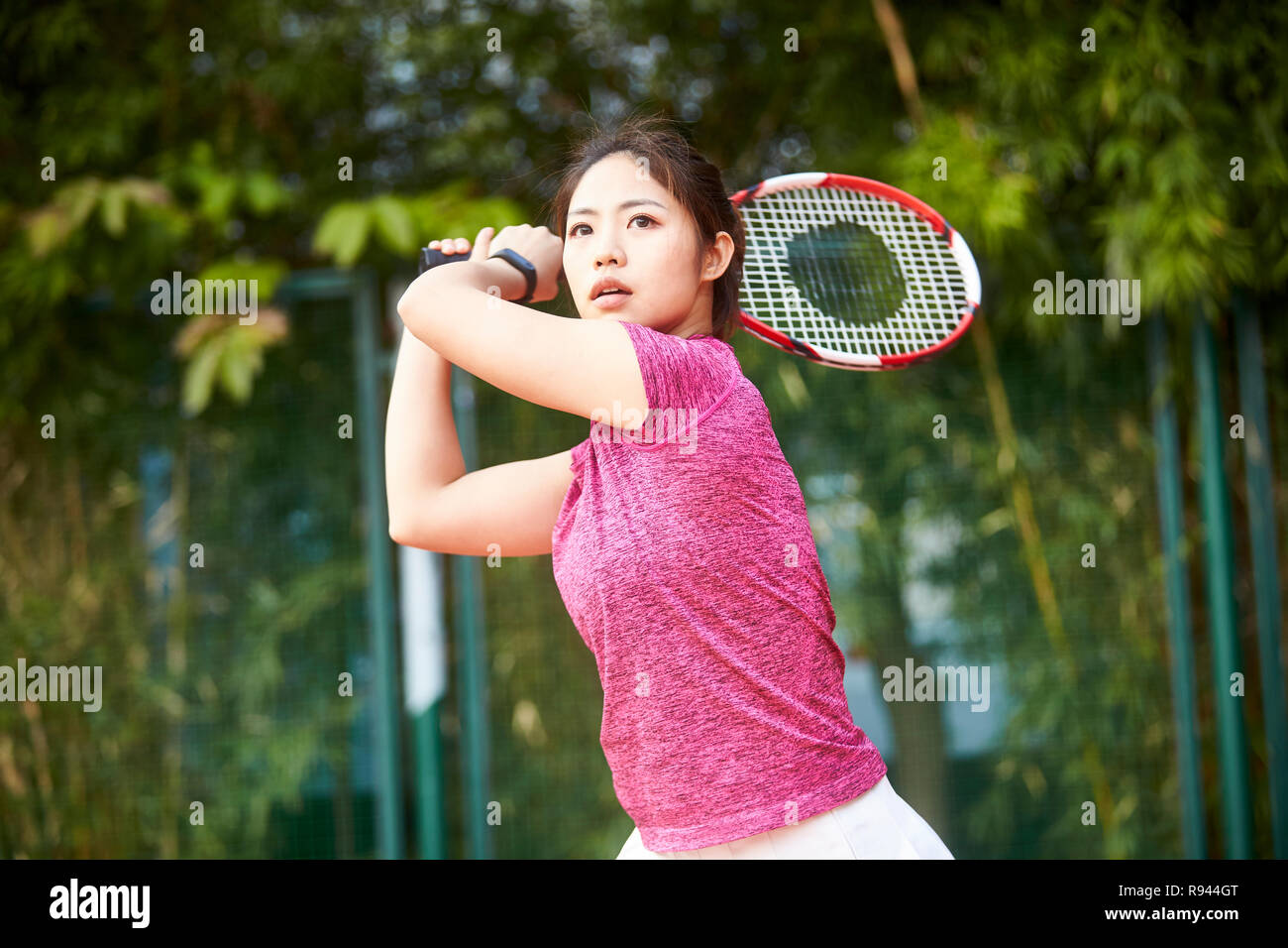 Junge asiatische Frau weibliche Tennisspieler schlagen den Ball mit der Vorhand Stockfoto