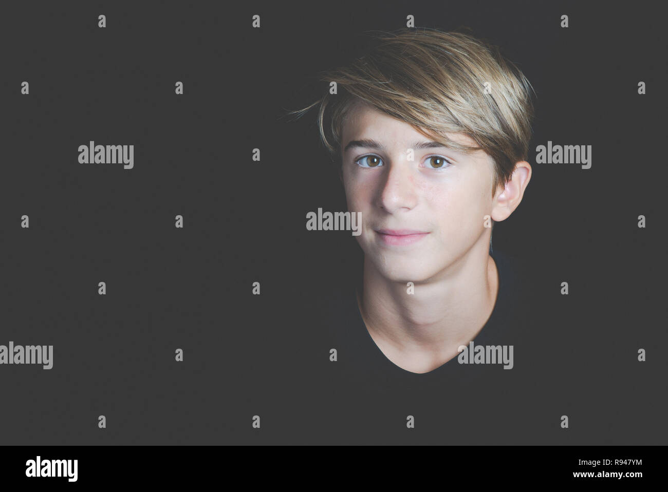Junge lächelnde junge Portrait auf schwarzem Hintergrund - Begriff der Adoleszenz ohne Probleme Stockfoto