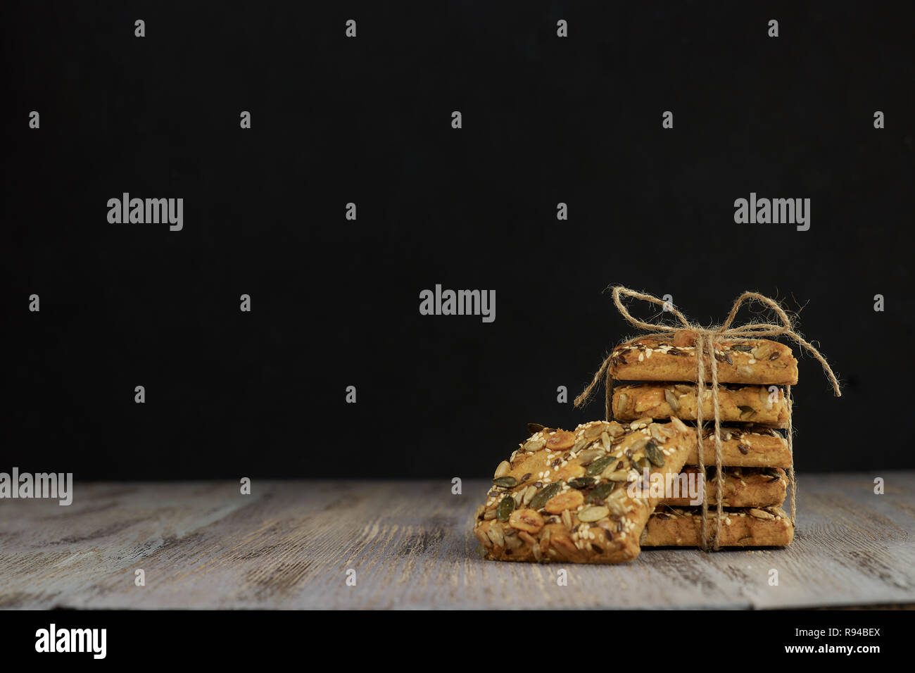 Ein von Shortbread Cookies mit verschiedenen Arten von Nüssen Stack mit einem köstlichen Kaffee oder Tee auf einem dunklen Holztisch. horizontale Ansicht. Stockfoto