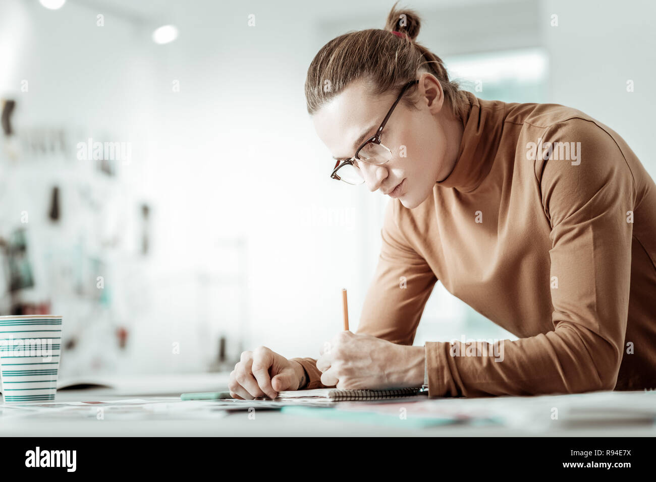 Gutaussehenden jungen blonden Designer von Mode Schule Skizzen machen Stockfoto