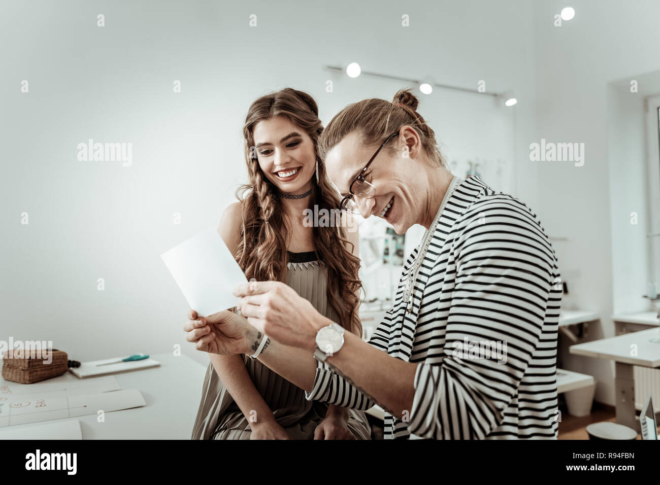 Langhaarige Designer Brillen und ein hübsches Modell im Bild lachen Stockfoto