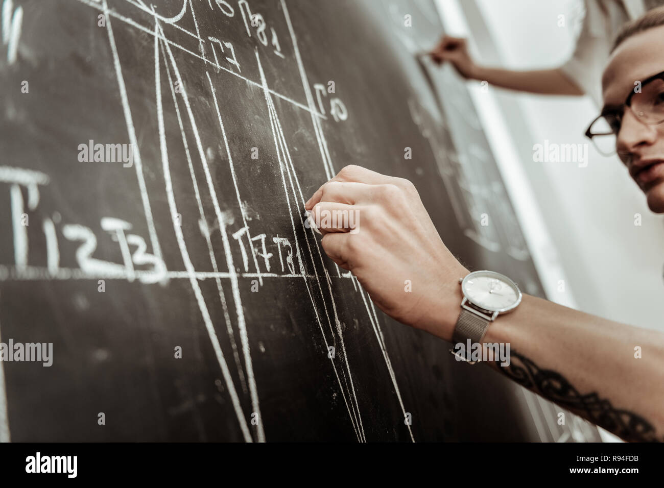 Hübscher junger langhaariger Designer Brillen Suche konzentriert Stockfoto