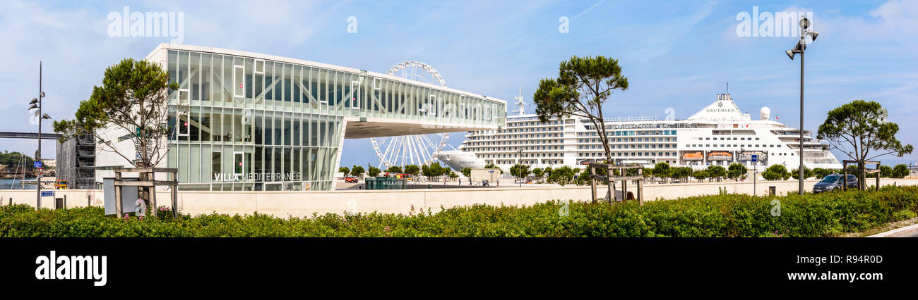 Panoramablick auf die Villa Mediterranee Gebäude in Marseille, Frankreich, mit ein Riesenrad und ein Kreuzfahrtschiff im Hintergrund. Stockfoto