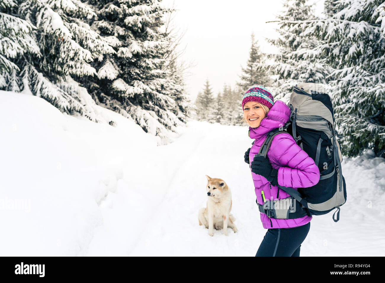 Happy girl Wandern in weiss Winter Wald mit Akita Hund. Erholung Fitness und gesunde Lebensweise draussen in der Natur. Inspirational Winterlandschaft. Stockfoto