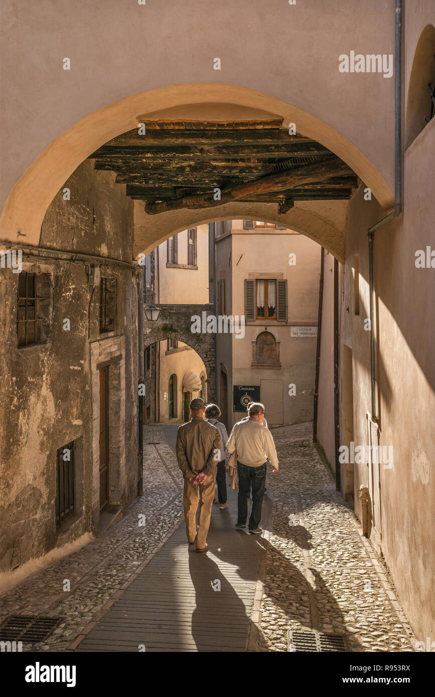 Gruppe von Menschen zu Fuß die Via Plinio il Giovane, Passage im historischen Zentrum von Spoleto, Umbrien, Italien Stockfoto
