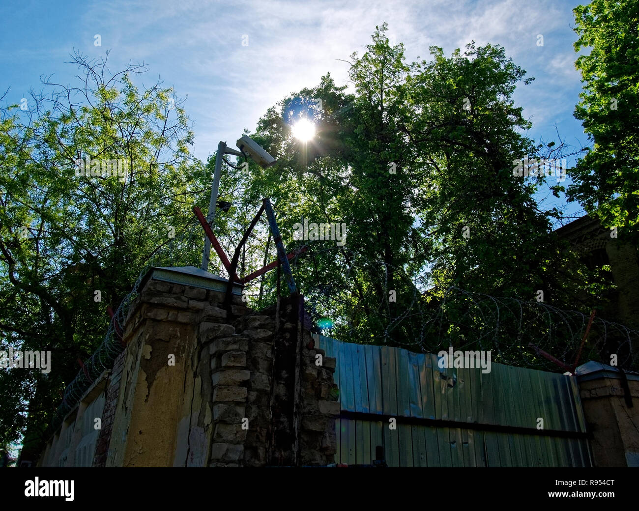 Stacheldraht über Ziegel Zaun im Frühjahr, Moskau Stockfoto