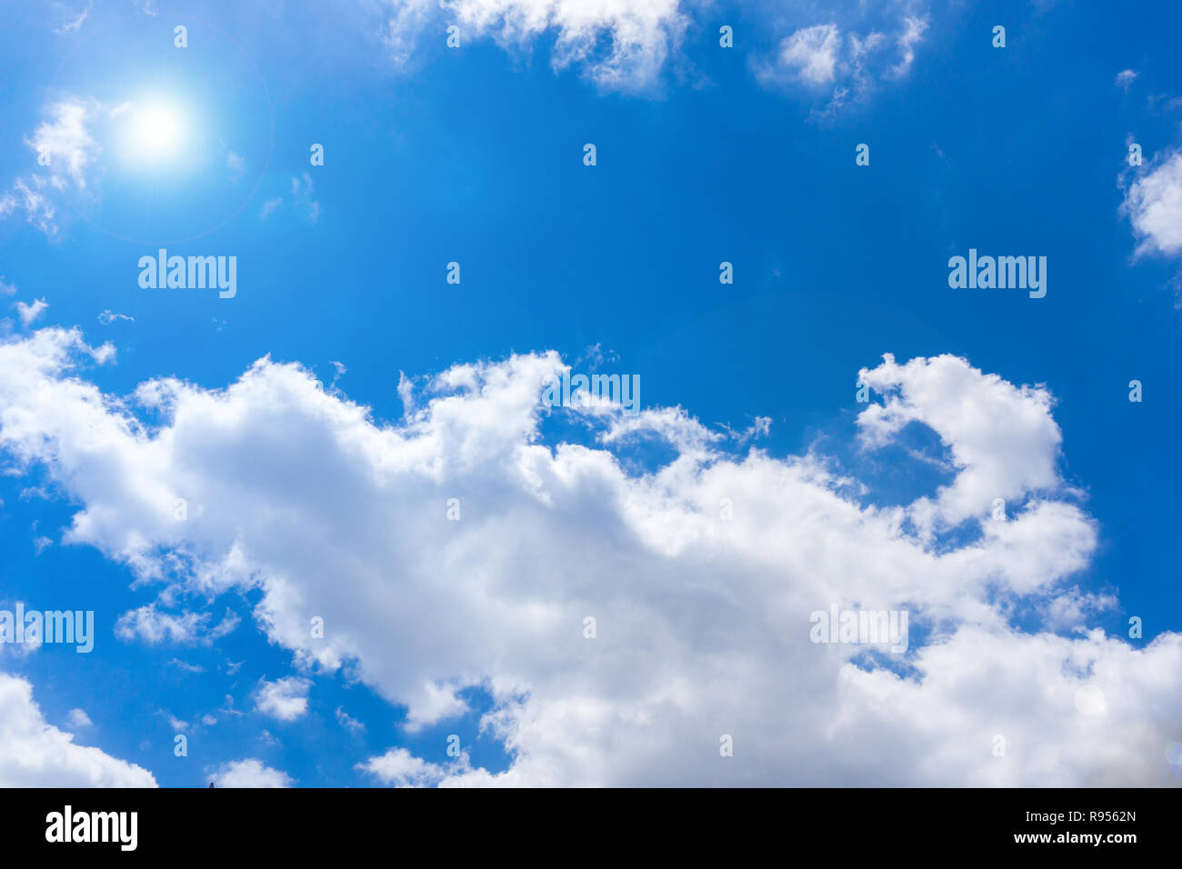 Flauschigen weißen Wolken und Sonnenschein vor blauem Himmel. Stockfoto