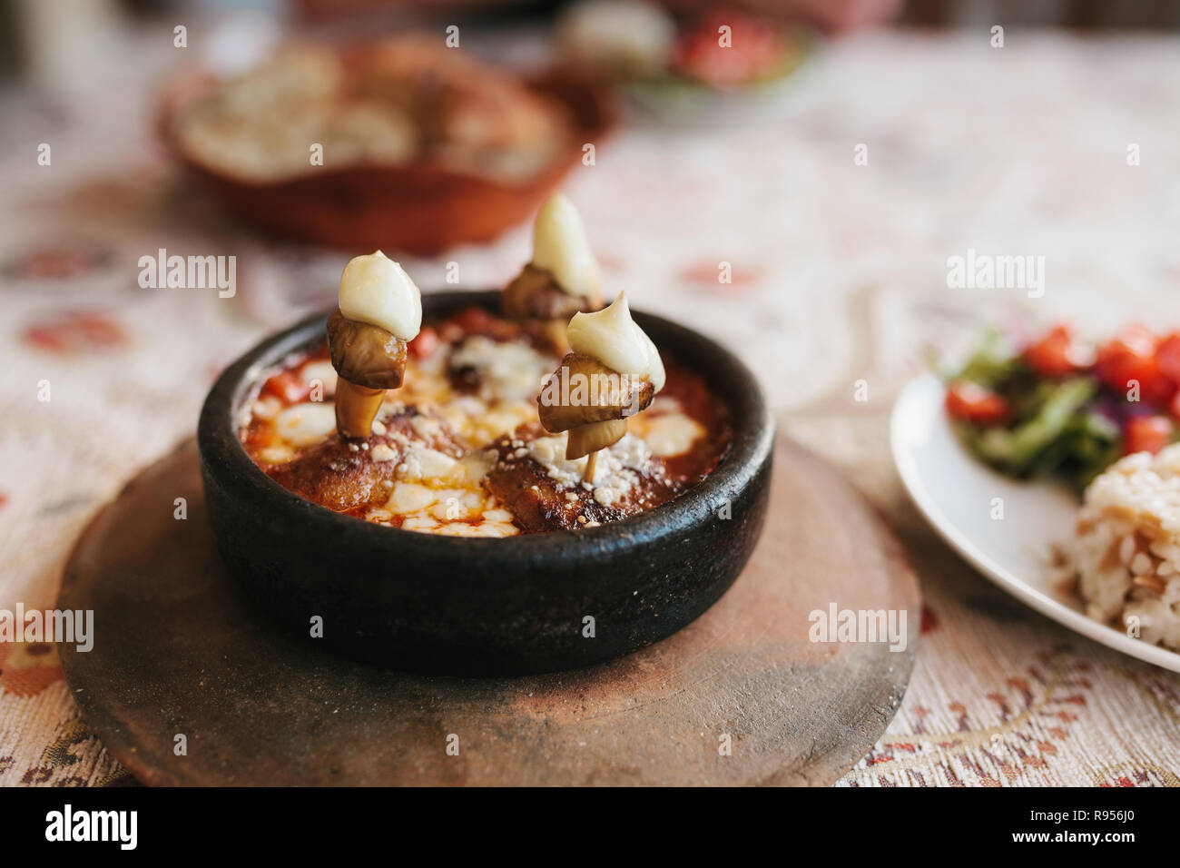 Close-up-Teller mit Pilzen und weißer Soße in der Schüssel auf Holz Stativ. Menü im Restaurant. Traditionelle türkische Speisen. Stockfoto