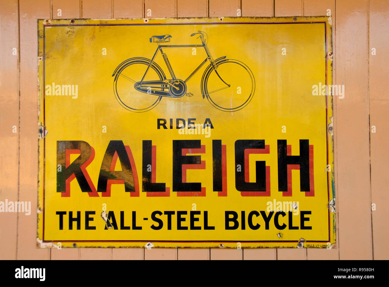 Alte Metall Werbefläche für Raleigh Fahrräder auf dem Display an der Wand am Bahnhof Stockfoto