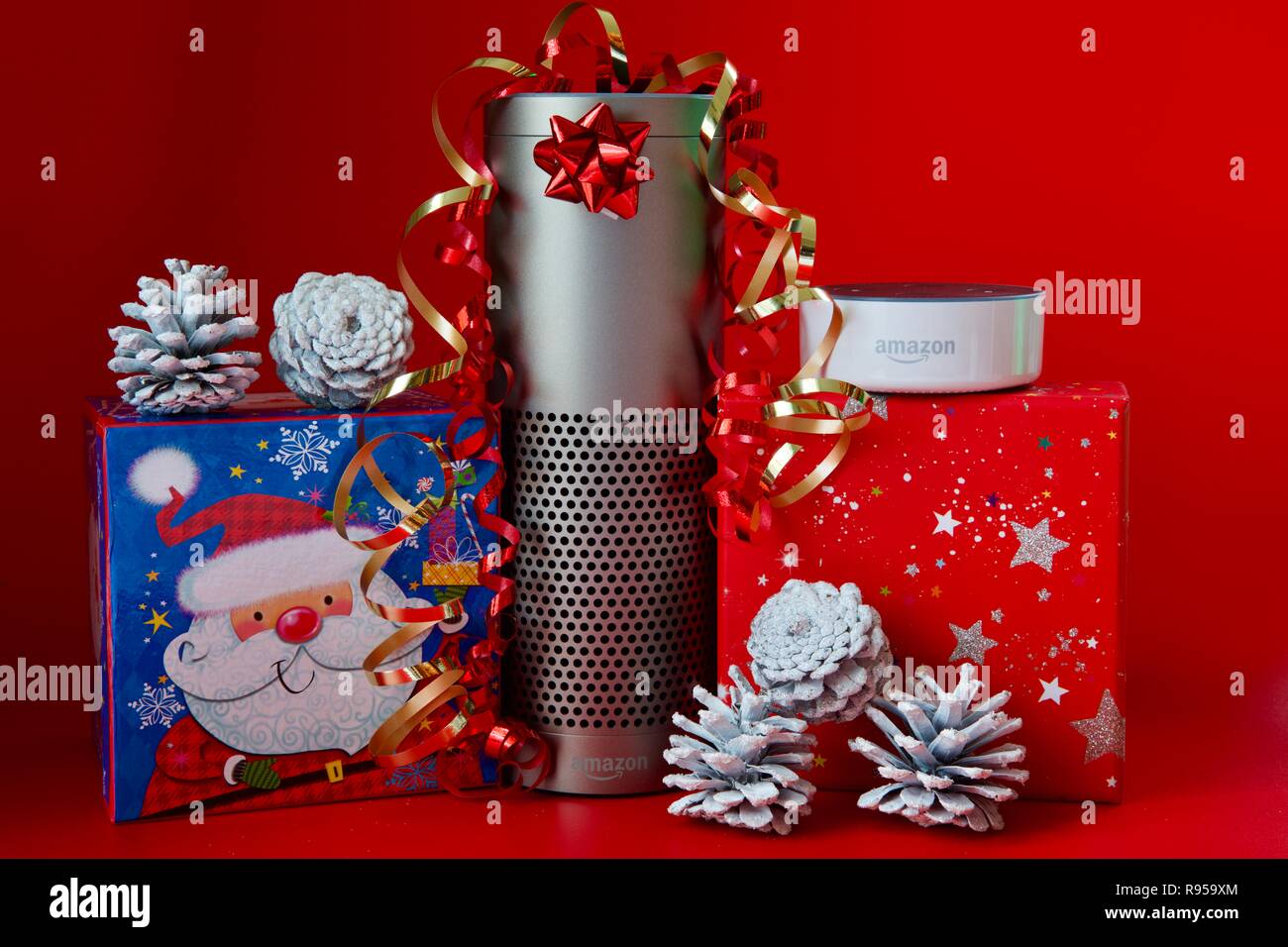 Amazon Echo und Echo Dot mit Weihnachtsschmuck auf rotem Hintergrund Stockfoto