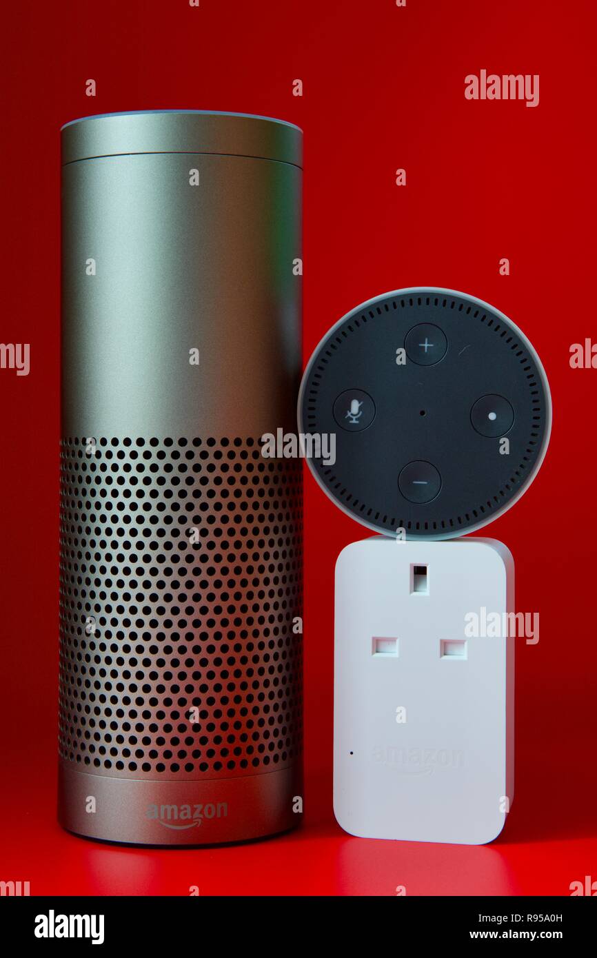 Amazon Echo, Echo Dot und Smart Plug auf rotem Hintergrund Stockfoto