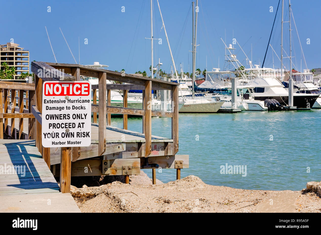Ein Schild warnt die Menschen, wenn sie mit einem Sturm - beschädigte Pier, 12.08.23, 2018 in Port Aransas kommunalen Hafen in Port Aransas, Texas, vorsichtig zu sein,. Stockfoto