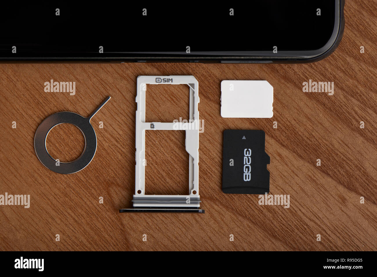 SIM-Karte und microSD-Kartensteckplatz mit Werkzeug zum Entfernen an der Seite des Smartphones Stockfoto