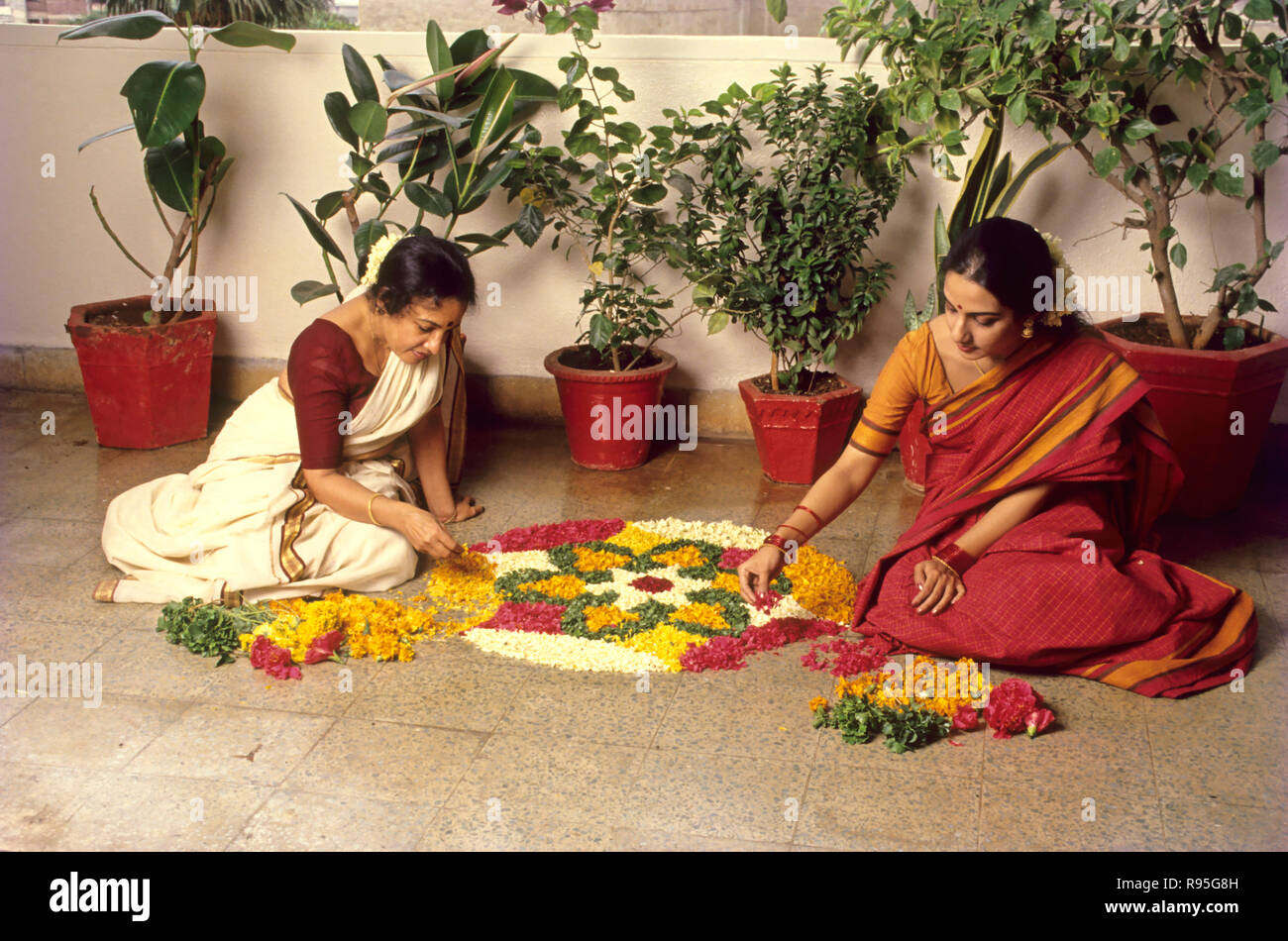 Frauen, die Blumenrangoli machen, Onam Festival, Indien Stockfoto