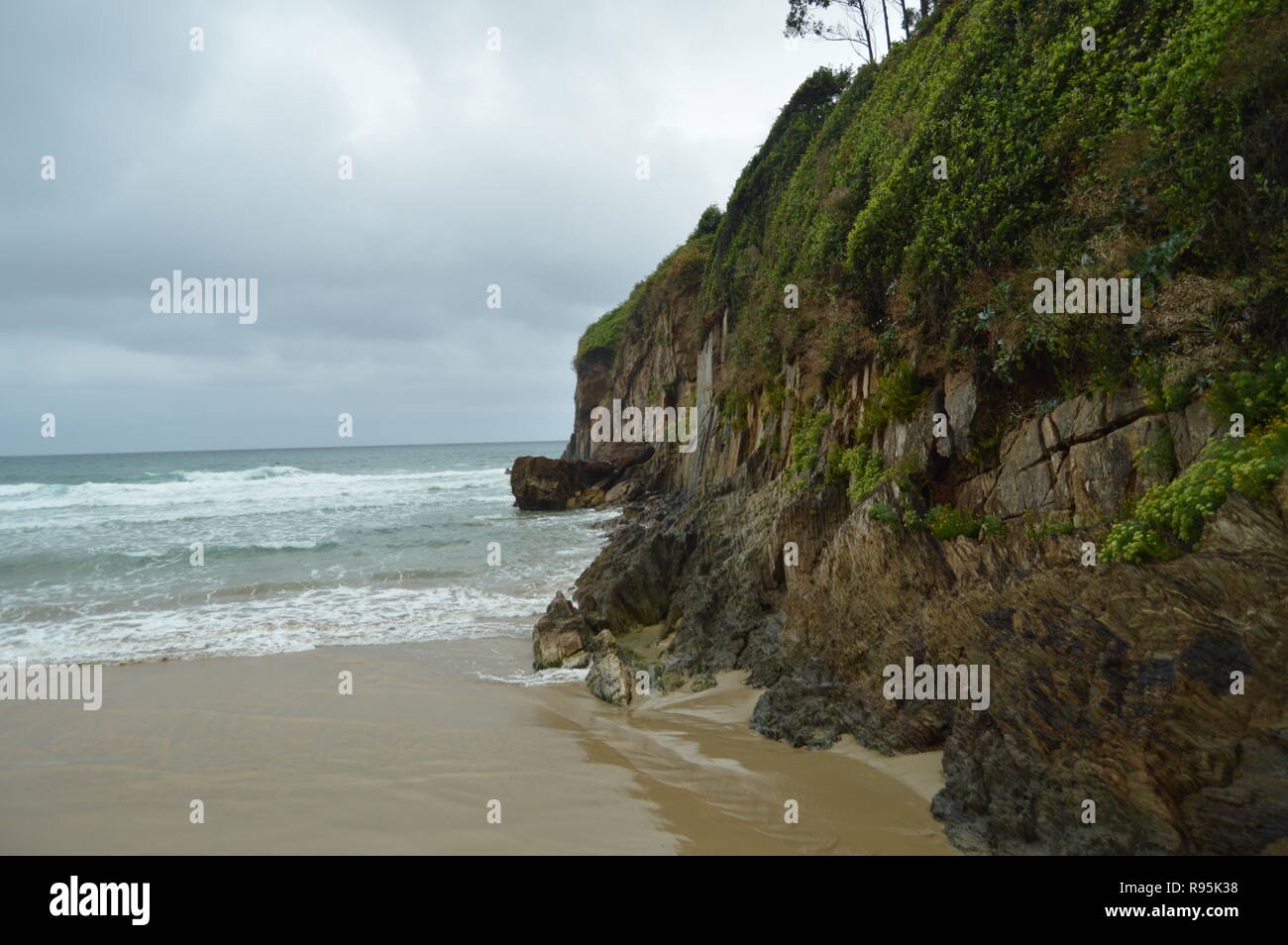 Schönen grünen Felsen am Strand von El Aguilar an einem regnerischen Tag. Juli 29, 2015. Landschaften, Natur, Reisen. Muros De Nalon, Asturien, Spanien. Stockfoto