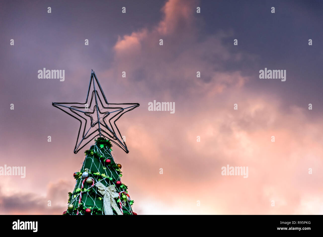 Stern auf der Oberseite des künstlichen Weihnachtsbaum gegen Sonnenuntergang Himmel in Guatemala, Mittelamerika Stockfoto