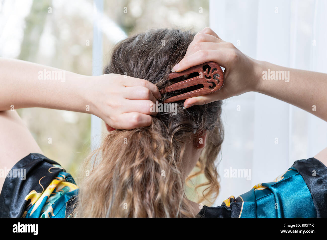 Closeup Portrait von weiblichen zurück, junge brünette Frau Haare macht mit  drei Zinken Holz- Gabel, Chinesische, Asiatische stick, Haarnadel, im Hause  stehen, Haus Stockfotografie - Alamy