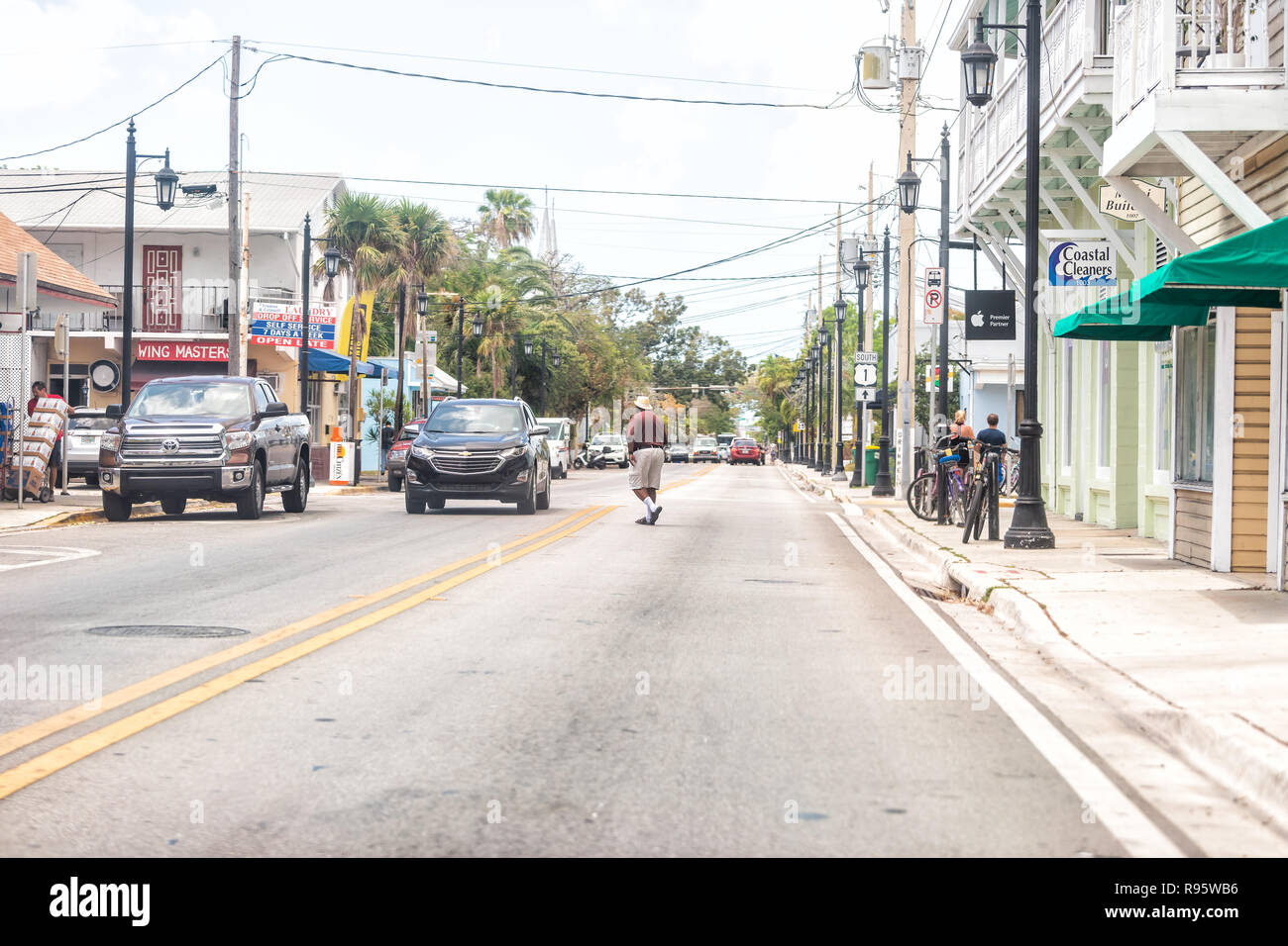 Key West, USA - Mai 1, 2018: Truman Avenue in Florida keys Stadt, städtische Blick auf Straße, Straße, Autos mit afrikanischen amerikanischen Mann überfahrt, jaywalking Stockfoto