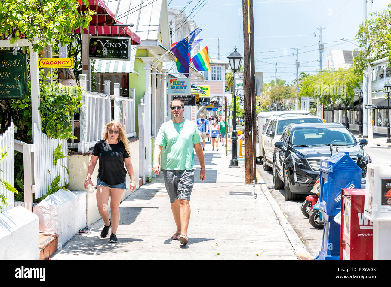 Key West, USA - Mai 1, 2018: Menschen, Paar auf Duval Street mit Tropical Inn, Weinstube, Restaurant, Cafe auf dem Bürgersteig, parkende Autos in Florida Stockfoto