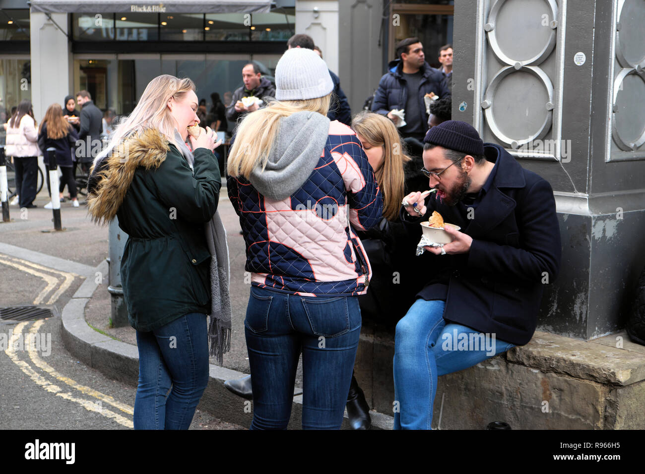 Junge Menschen Essen steht auf Stoney Straße Braten Restaurant Floral Hall in Borough Market, South London England UK KATHY DEWITT Stockfoto