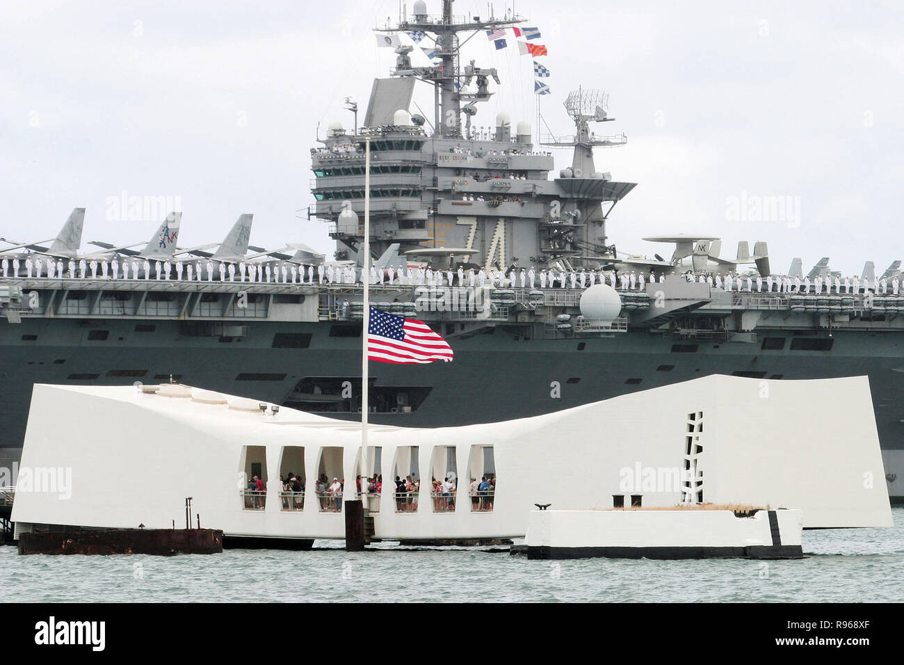 Matrosen an Bord der USS John C Stennis (CVN 74) ehrt die USS Arizona Memorial machen wie sie in Pearl Harbor, Hawaii ankommen. DoD Foto von Petty Officer 1st Class William R. Goodwin, US Navy. Stockfoto