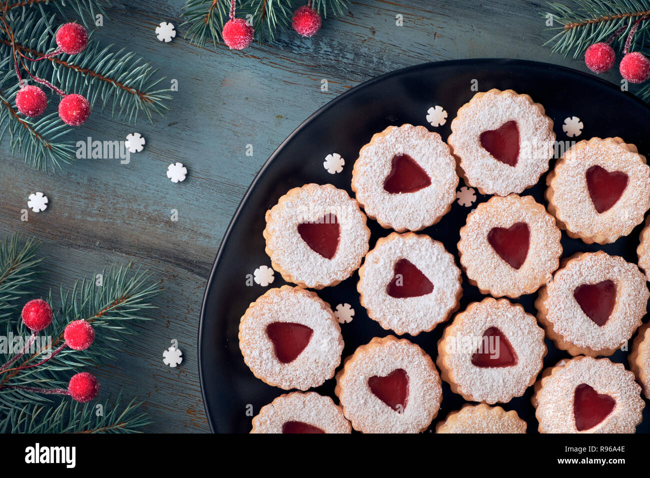 Blick von oben auf die traditionellen Linzer Plätzchen mit roter Marmelade Herz auf dunklem Hintergrund. Deutsche und Österreichische traditionelle winter Snack. Stockfoto