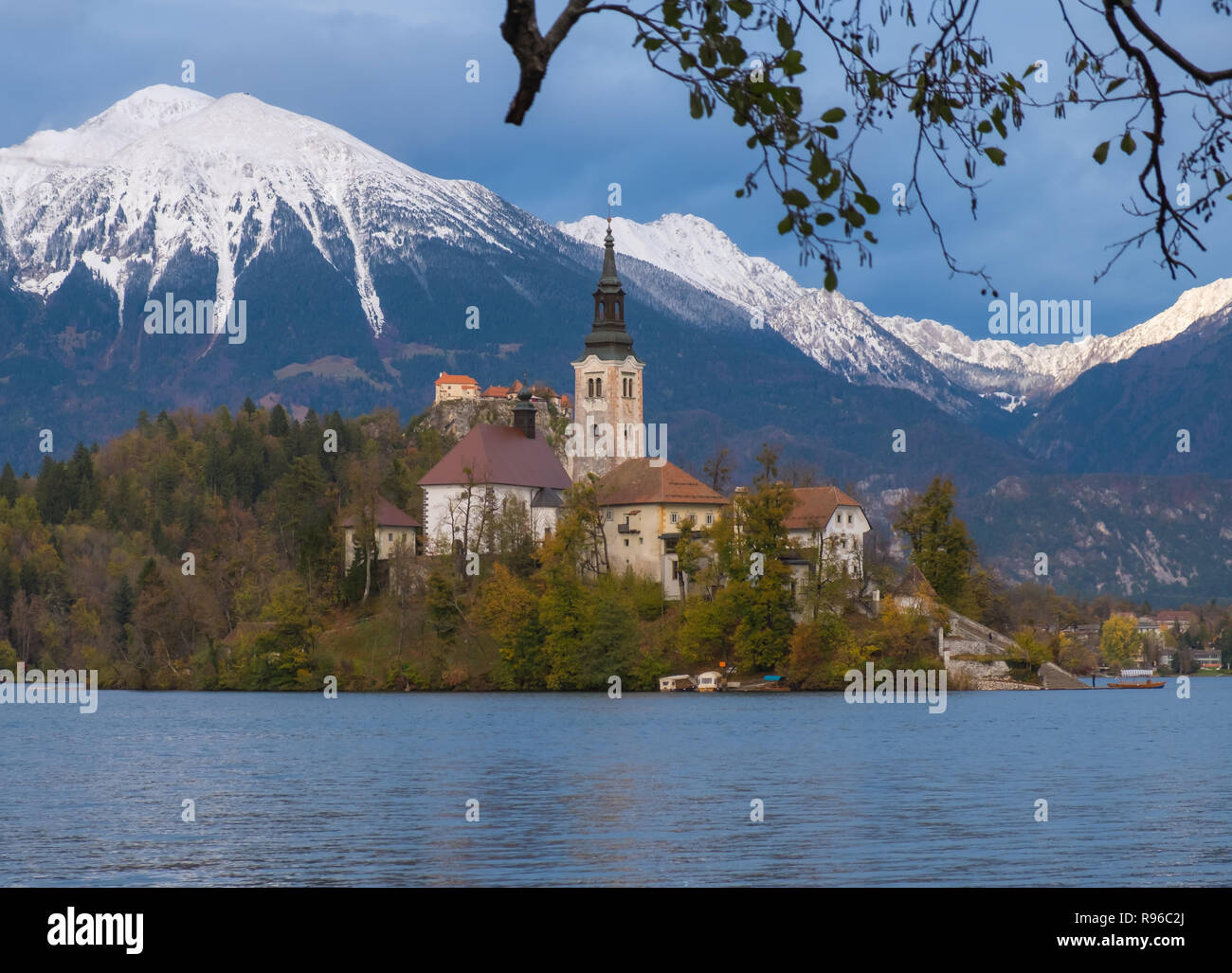 Wallfahrtskirche der Himmelfahrt der Maria auf einer Insel im See von Bled, Slowenien. Herbst, mit Turning Leaves Framing der Insel und schneebedeckten Stockfoto
