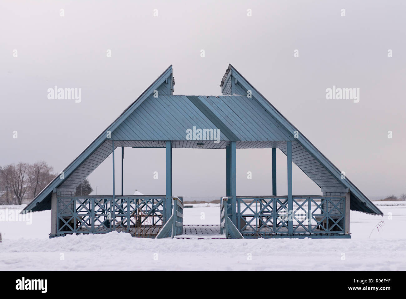 Holz- bläuliche Deck stehend auf einem gefrorenen Meer Wasser am Strand serrounnded mit viel Schnee Stockfoto