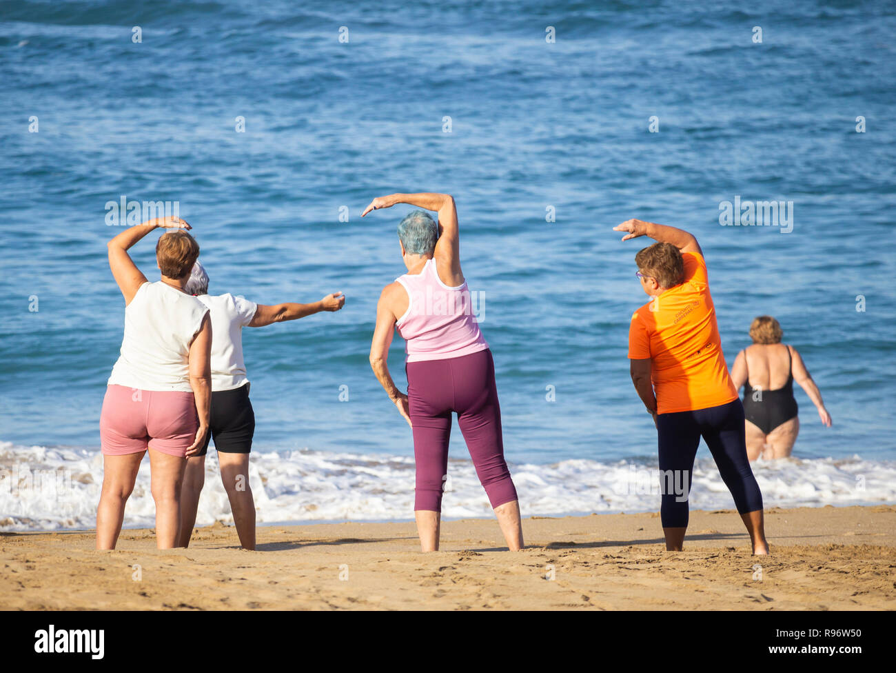 Ältere Frauen, die sich am Strand während passen Klasse in Spanien halten Stockfoto