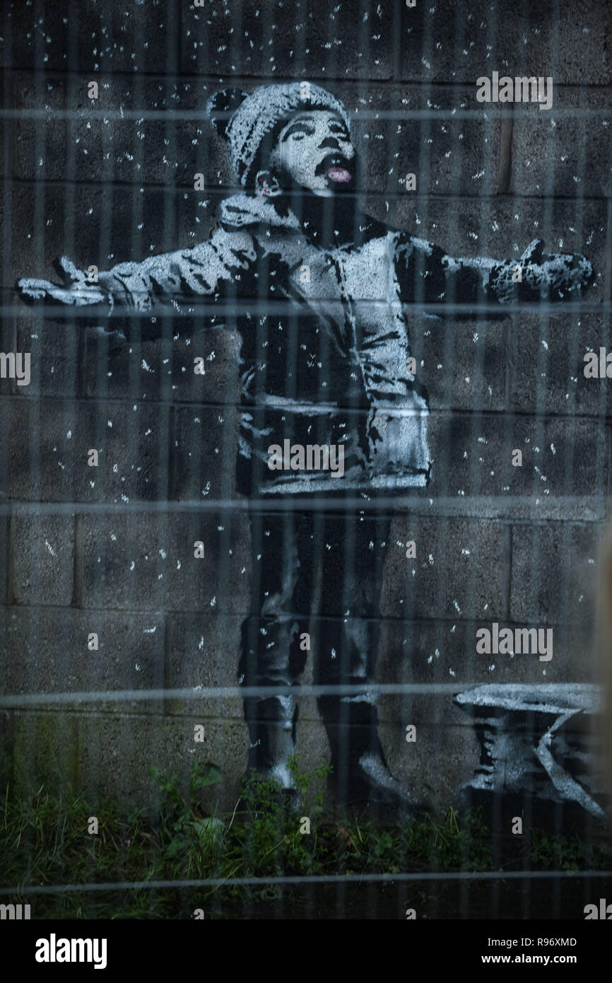 Port Talbot, Wales, UK. Dezember 2018 20. Menschen strömen in eine Garage in der Stahl Stadt Port Talbot in South Wales, Großbritannien, nachdem es wurde bestätigt, dass eine Arbeit von Graffiti auf Es erscheint, von dem Künstler Banksy hergestellt wurde. Das Kunstwerk zeigt ein Kind mit den Armen in der Luft gehalten und wurde von dem, was scheint, mit Schnee bedeckt, ist aber in der Tat, die Asche aus einem brennenden Mülltonne, auf der anderen Seite der Garage Ecke gemalt. Der weltbekannte Künstler, bestätigt, dass es seine Arbeit war über seine instagram Konto. Credit: Robert Melen/Alamy leben Nachrichten Stockfoto