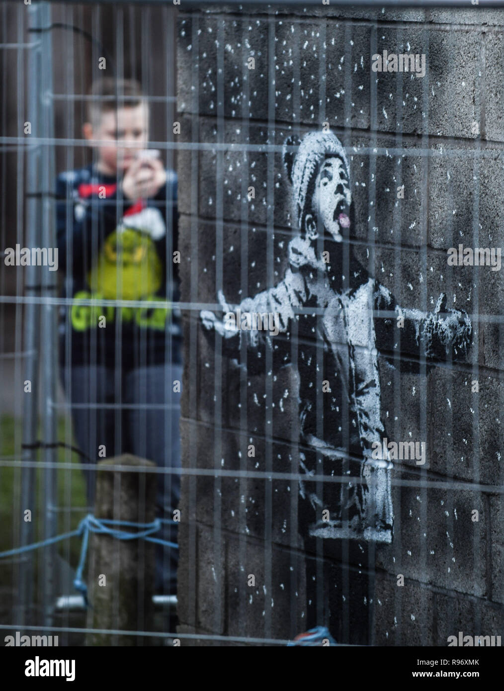 Port Talbot, Wales, UK. Dezember 2018 20. Menschen strömen in eine Garage in der Stahl Stadt Port Talbot in South Wales, Großbritannien, nachdem es wurde bestätigt, dass eine Arbeit von Graffiti auf Es erscheint, von dem Künstler Banksy hergestellt wurde. Das Kunstwerk zeigt ein Kind mit den Armen in der Luft gehalten und wurde von dem, was scheint, mit Schnee bedeckt, ist aber in der Tat, die Asche aus einem brennenden Mülltonne, auf der anderen Seite der Garage Ecke gemalt. Der weltbekannte Künstler, bestätigt, dass es seine Arbeit war über seine instagram Konto. Credit: Robert Melen/Alamy leben Nachrichten Stockfoto