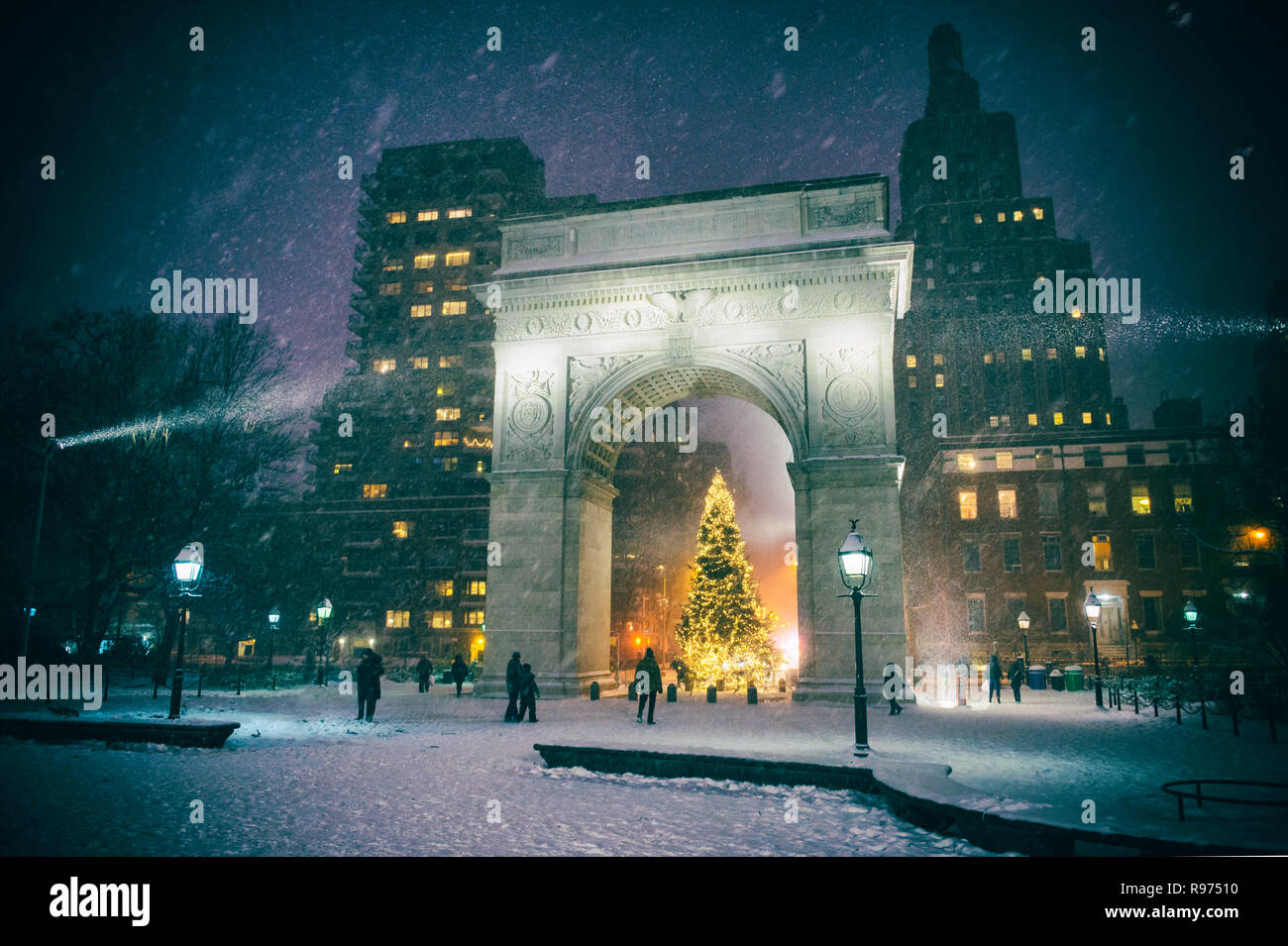 Winterurlaub Nacht Blick auf den Washington Square Park mit einem Weihnachtsbaum unter fallenden Schnee in New York City Stockfoto