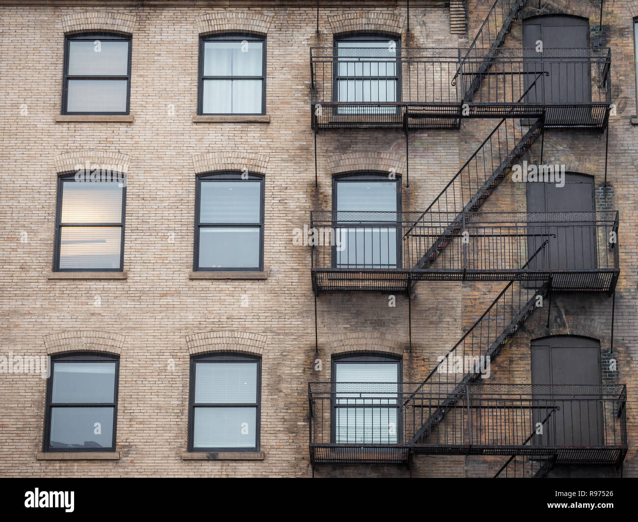 Notausgang Treppen und Leiter, aus Metall, auf einer typischen Nordamerikanischen alten Backsteingebäude aus dem alten Montreal, Quebec, Kanada. Diese Treppen, gemacht wurden. Stockfoto