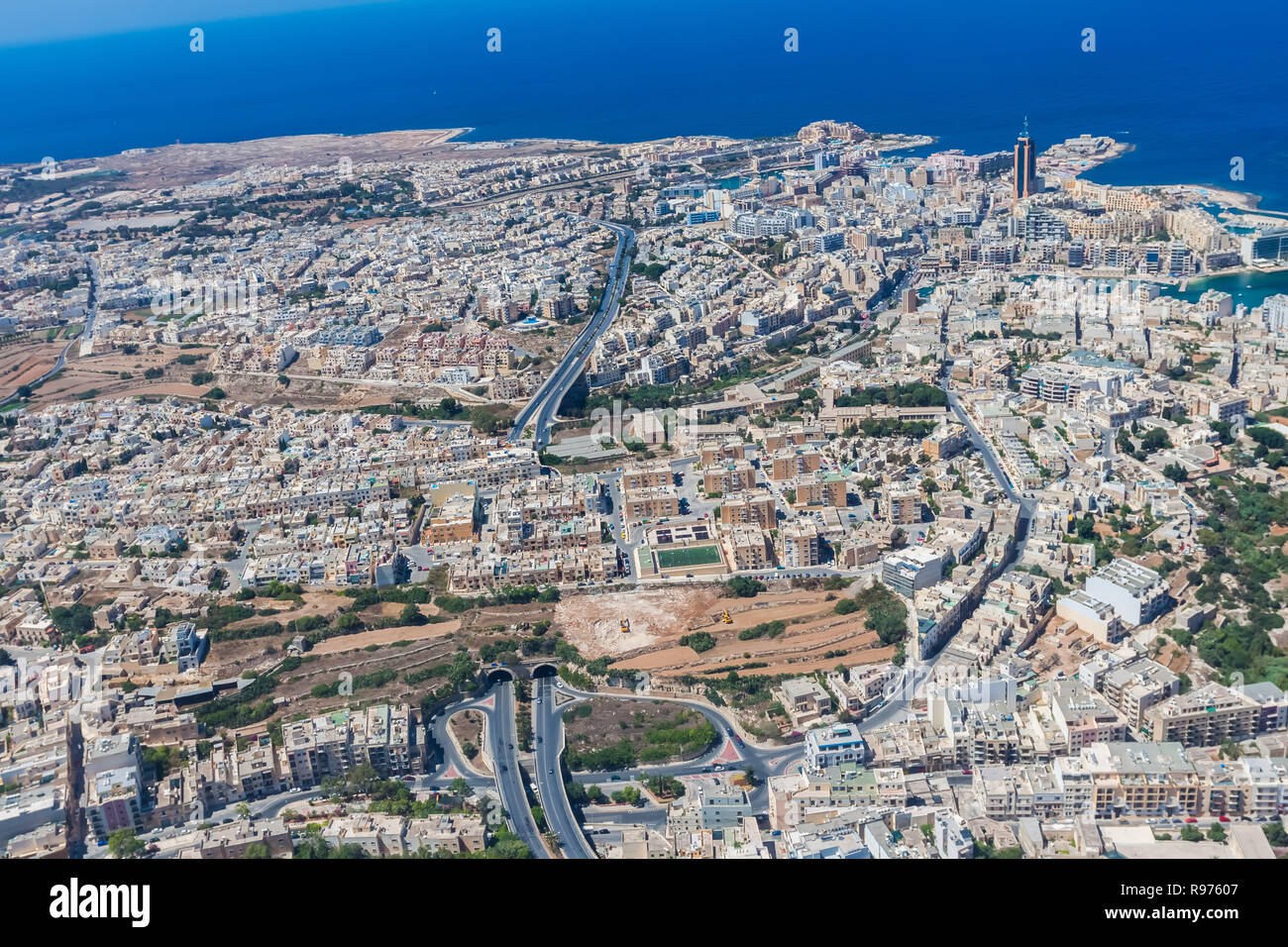 Luftaufnahme der städtischen Malta. Tunnel auf der Autobahn 1 bei Ta'Tage Stadt und Stadtteil Paceville, Teile von St. Julian's (San Giljan) Stadt von oben. Bausteine der Wohnanlagen, Schlafräume. Stockfoto