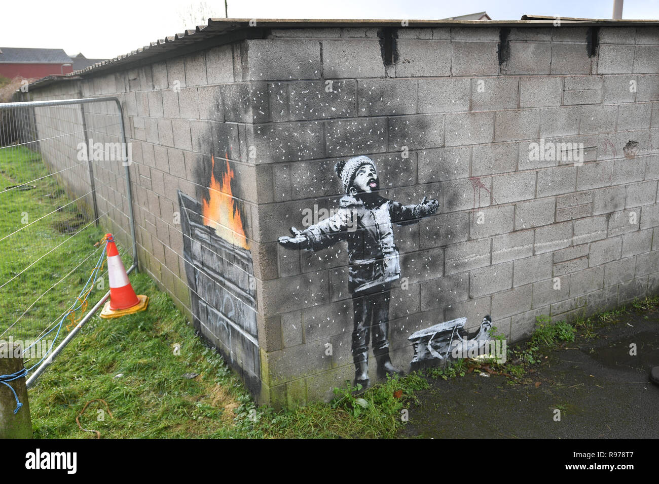 Kunstwerke von Street Artist Banksy, die auf eine Garage Wand in Taibach, Port Talbot, South Wales erschienen ist. Das Bild erschien über Nacht und zeigt ein Kind, das in den fallenden Asche und Rauch von einem Feuer in einem fort. Stockfoto