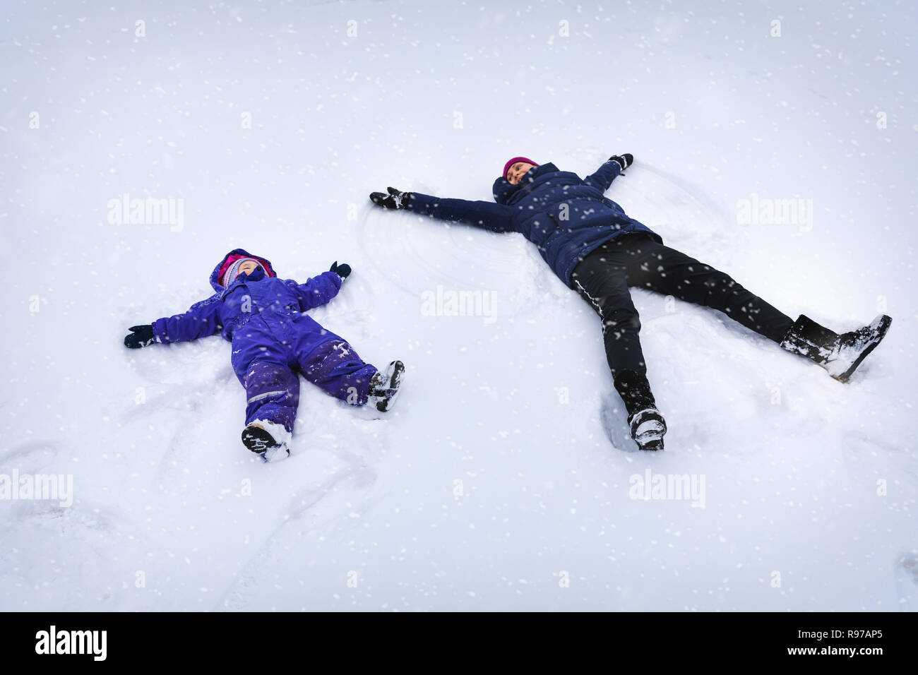 Mutter und Kind, das die Engel im Schnee Stockfoto