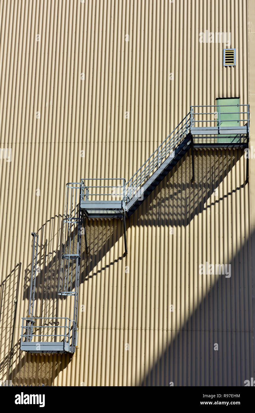 Abstraktes Muster aus Metall Notausgang Treppen und vertikal orientierten Wellblech verkleideten Gebäude Stockfoto