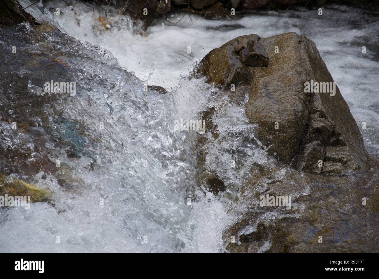 Detail von Wasser drastisch Spritzen gegen einen Felsen im Fluss Stockfoto