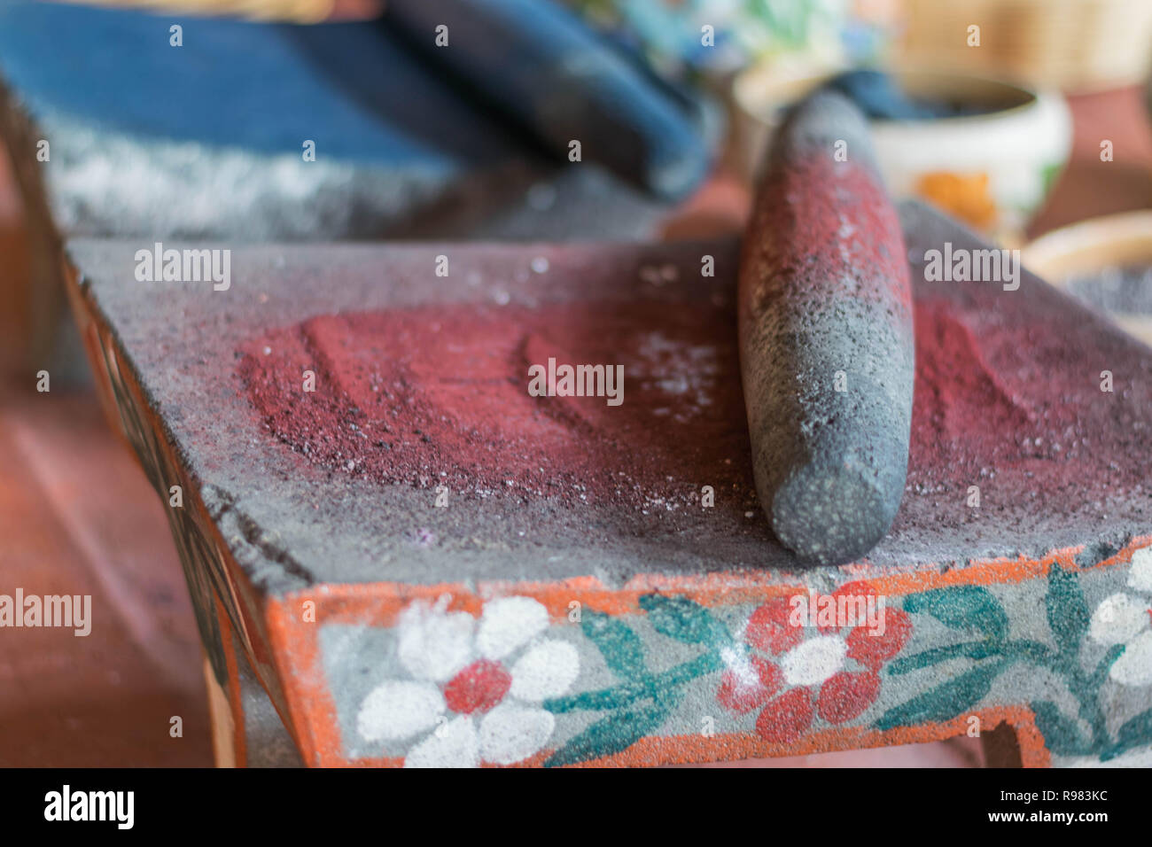 Isoliert, aus nächster Nähe erschossen von dekorativen Schleifen der Steine mit roten und blauen Pflanzen Boden in Pulver, Oaxaca, Mexiko Stockfoto