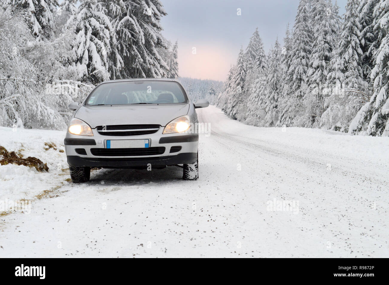 Ein Auto auf einer gefährlichen und rutschig Snowy Mountain Road Stockfoto