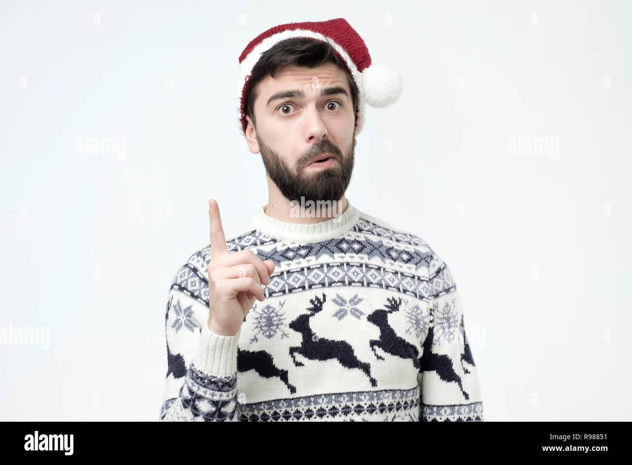 Hispanic Mann in rot weihnachten Kappe, Zeigefinger, Beratung Stockfoto