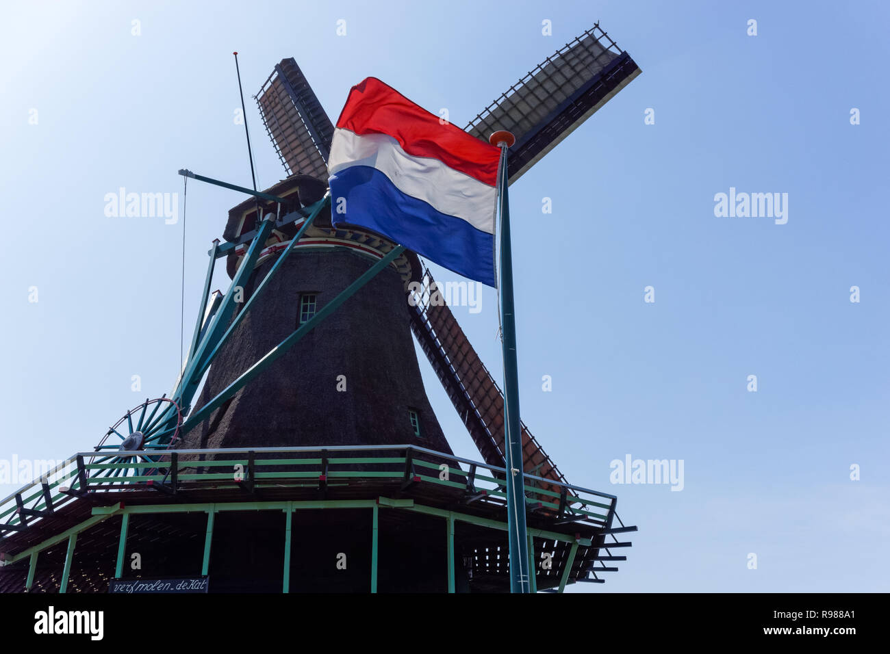 Holländische Windmühle und niederländische Flagge in Zaanse Schans in Niederlande Stockfoto