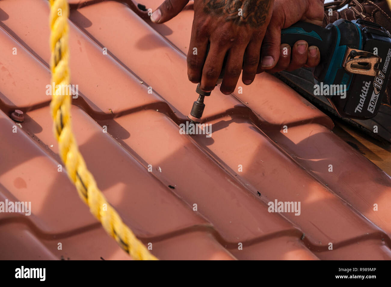 Mann mit elektrischen Bohrmaschine zu reparieren Roofing Stockfoto