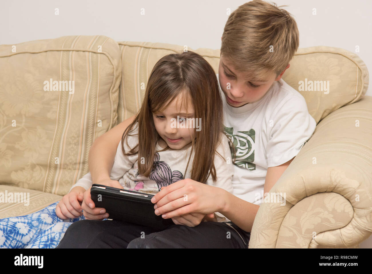 Digitale Gerät, Tablet-PC, iPad, älterer Bruder, jüngere Schwester mit Social Media, moderne Technologie Stockfoto