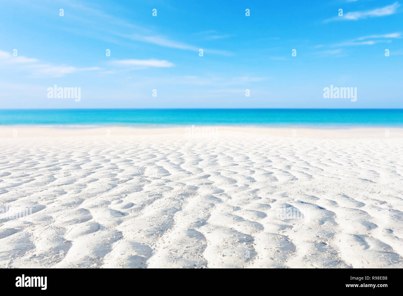 Weißer Sand Kurve oder tropischen Sandstrand mit verschwommenen, blaue Meer und blauer Himmel Hintergrundbild für Natur Hintergrund oder Sommer Hintergrund. Stockfoto