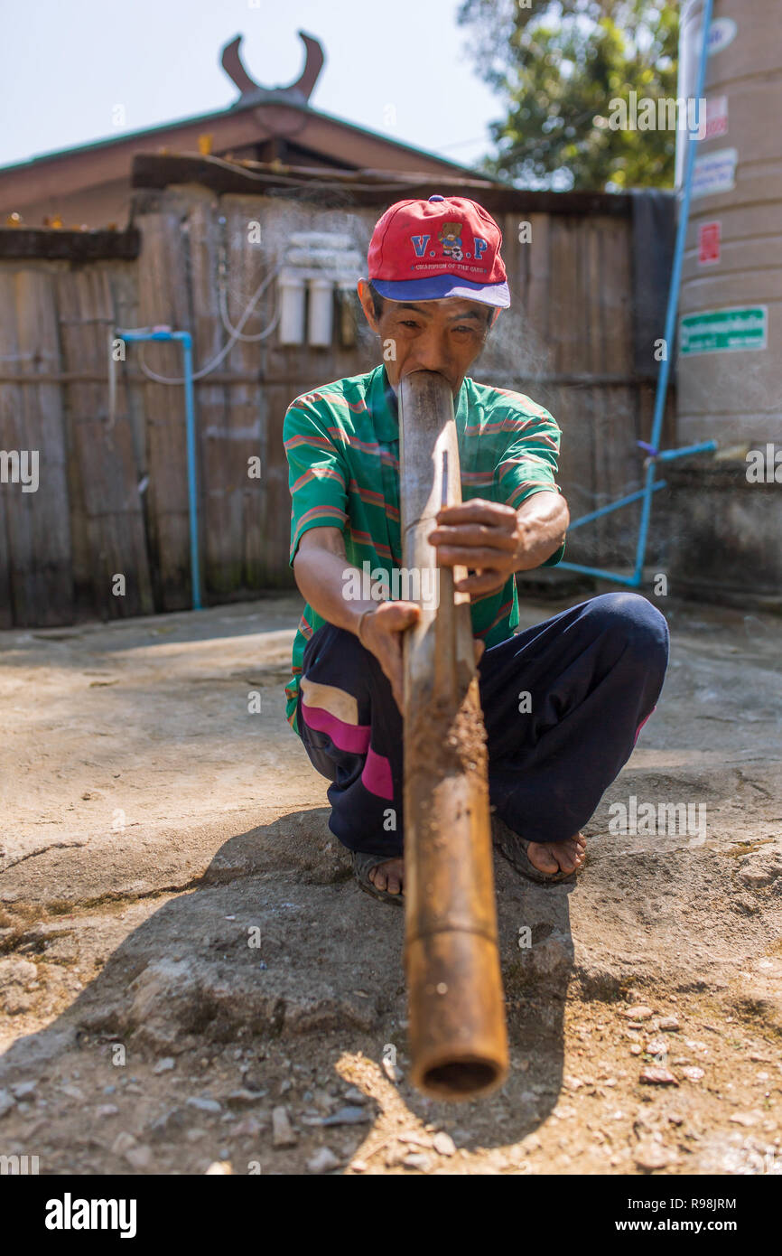 Chiang Rai, Thailand - Februar 8, 2017: Unbekannter ältere Akha Mann ist Rauchen traditionelle Tabak Pfeife im bergvolk der Akha Dorf im Norden Thail Stockfoto